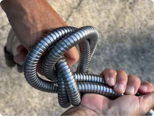 Garden Maestros - Elite Metal Hose watering a green lawn