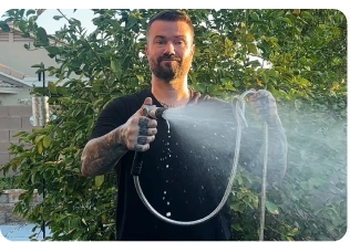 Hand adjusting the sprinkler dial on the lawn